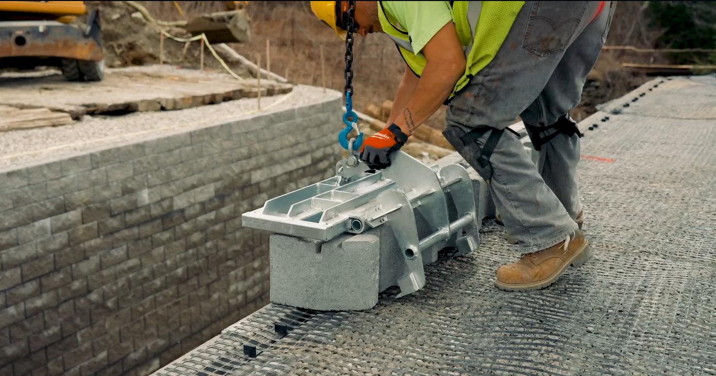 Construction worker safely lifting a concrete block with chain hoist and WingSet® system